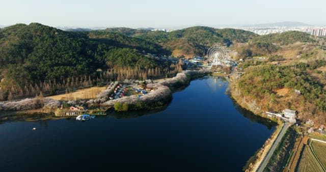 Amusement park near a lake surrounded by forests