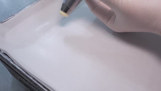 Piping batter onto a baking sheet in a professional kitchen