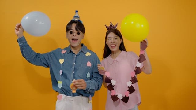 Two happy people celebrating with balloons