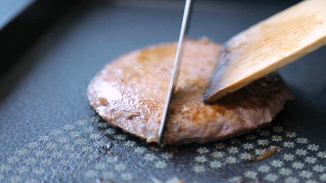 Cutting a juicy burger patty with a knife
