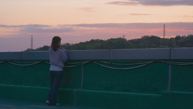 Two women looking at the sunset sky from the rooftop