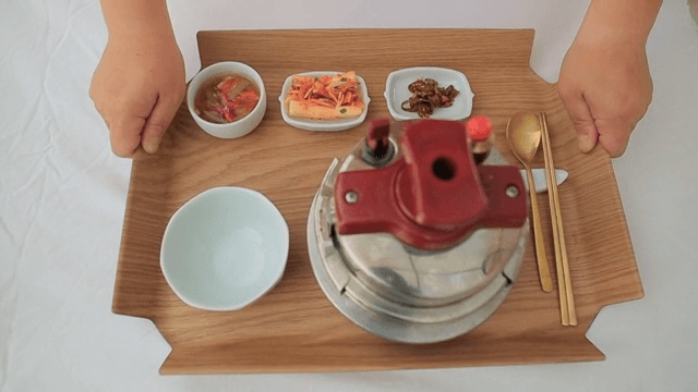 Tray of rice cooked in a pot with Korean side dishes such as kimchi