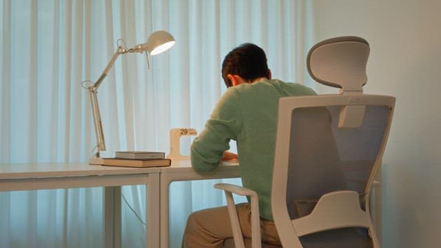 Man sitting at a desk in a calmly lit room