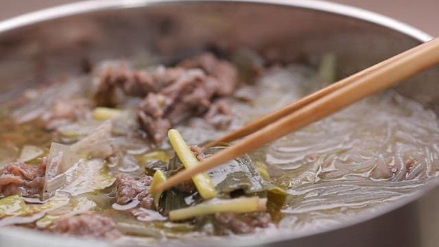 Chopstickful of savory yukgaejang with green onions