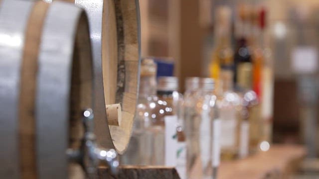 Brewing kegs and various bottles of liquor on a wooden table