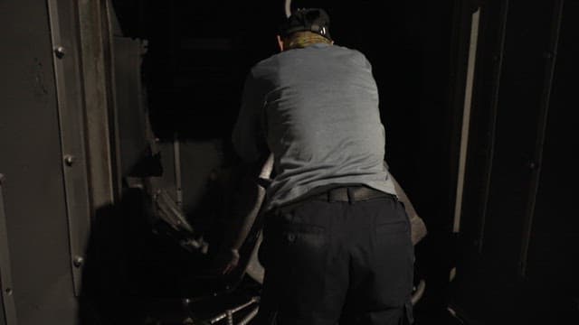 Worker putting metal parts into container