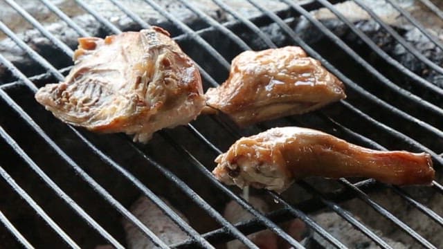 Chicken grilled on a wood-fired barbecue grill