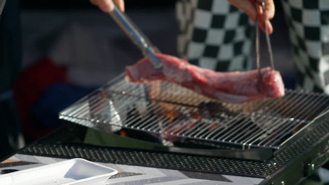 Grilling a large piece of meat on a barbecue grill outdoors