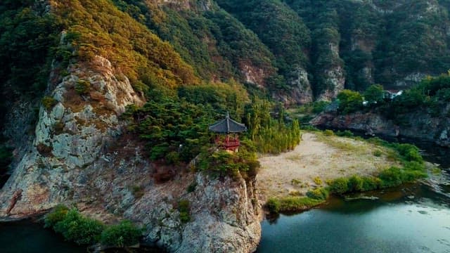 Serene Traditional pavilion on rocky cliffs surrounded by lush greenery