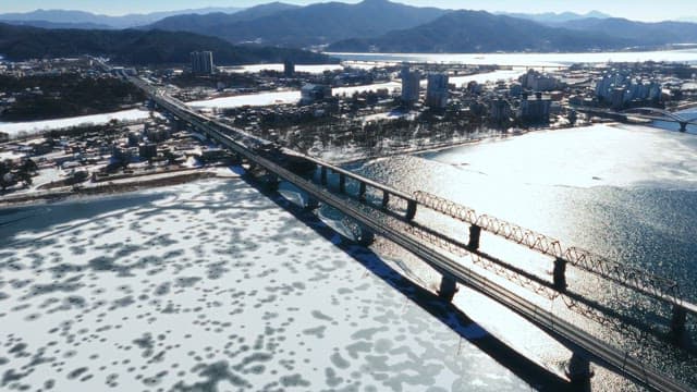 Winter Town with Bridge Over Frozen River