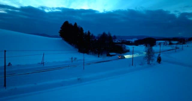 Twilight Snowscape with Passing Car
