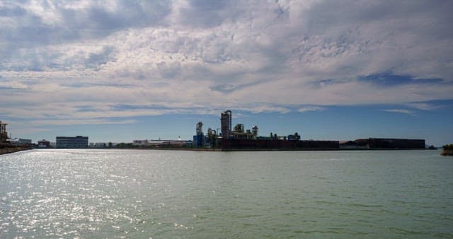 Industrial complex landscape near the sea from day to evening
