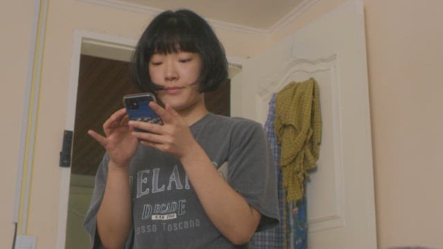 Woman focused on her phone in a cozy room