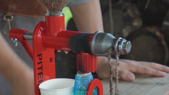 Hand pressing oil from seeds using a machine