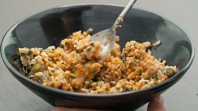Mixing deliciously seasoned dried radish greens rice with a spoon