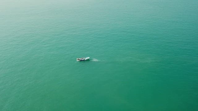 Small boat sailing on the vast, calm ocean