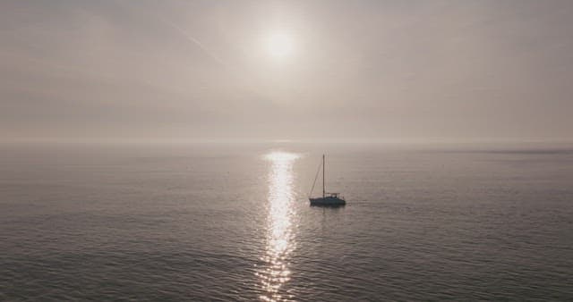 Yacht sailing on a calm sea at sunset