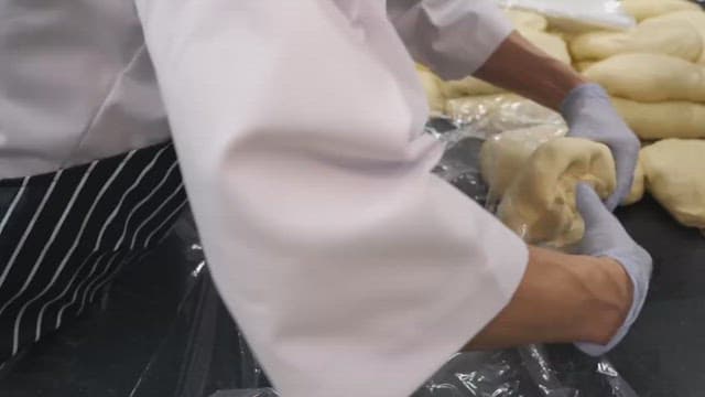 Baker kneading dough in a commercial kitchen with precision