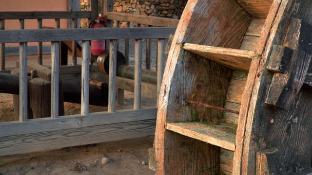 Wooden watermill on one side of a traditional house