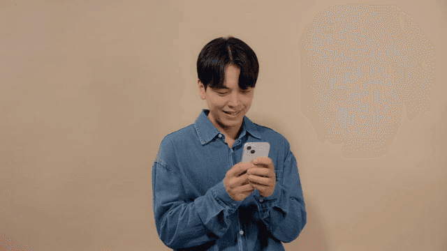 Man smiling while sending messages on his cell phone