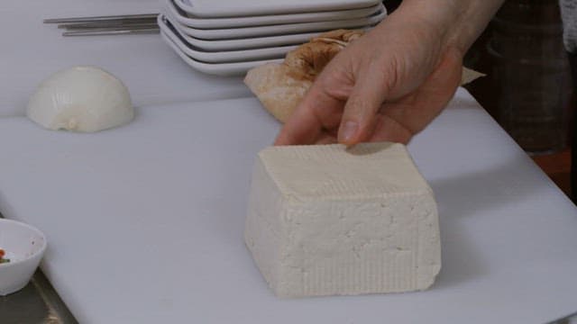Cutting tofu in the kitchen with a knife
