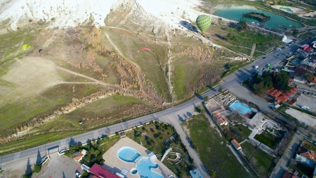 Paragliders Soaring Over the Hill and a Rural Landscape