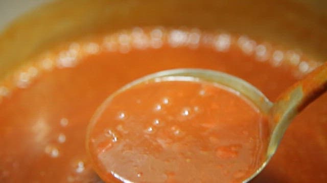 Tomato sauce being stirred in a pot