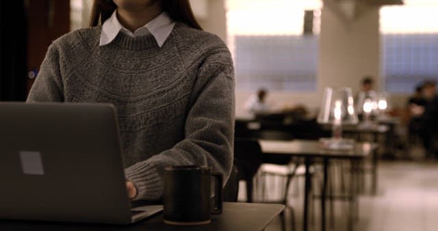Focused Student Working on Laptop in Cafe