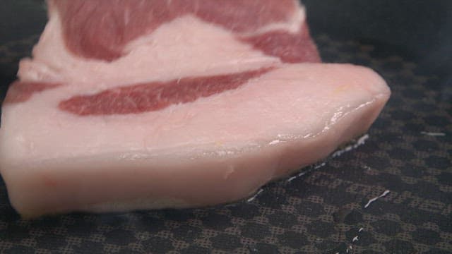 Pork belly sizzling on a hot pan