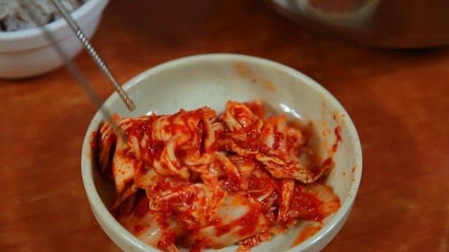 Kimchi in a bowl with rice on the side