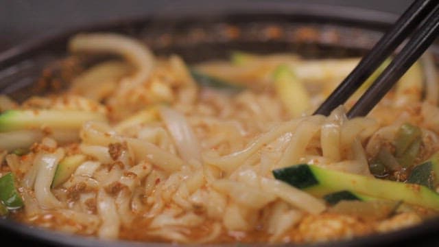 Chopstickful of spicy noodle soup from a hot pot