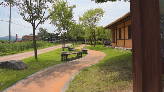 Serene Park Pathway with Traditional Korean House