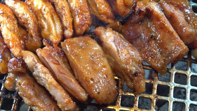 Spicy charcoal-grilled chicken on the grill