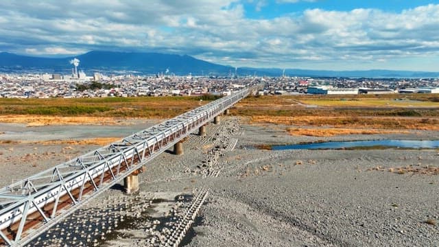 Train crossing a long bridge in a city