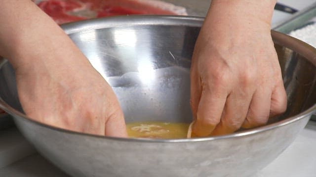 Meat coated in egg and fried in an oiled frying pan