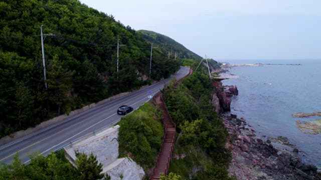 Coastal Road Along Lush Hillside and Sea