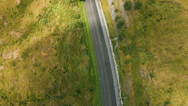 Shadow of a Green Hill Approaching a Winding Road