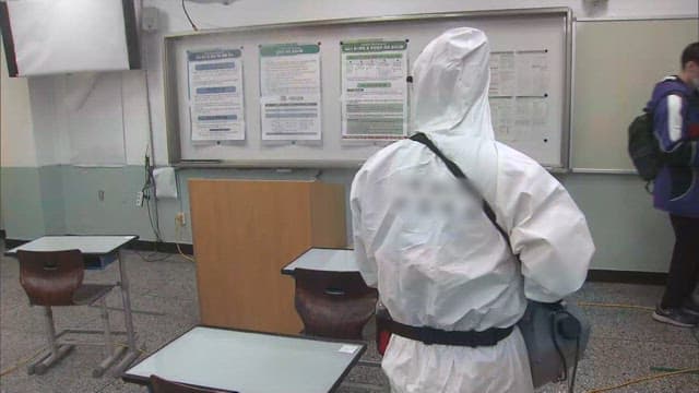 Person Sanitizing Classrooms in Protective Suit