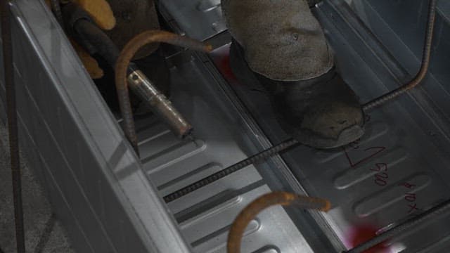 Worker welding metal beams indoors