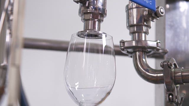 Automated machine filling water into a glass
