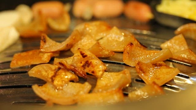 Grilling pork rinds on a metal grill