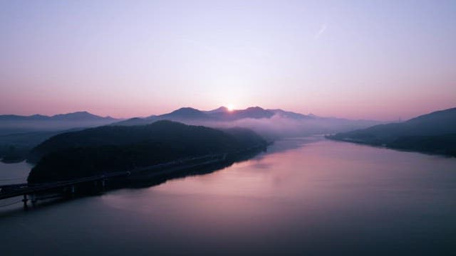 Serene Sunrise over Tranquil Mountains and River