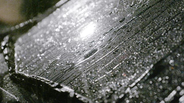 Rain falling on a car windshield at night