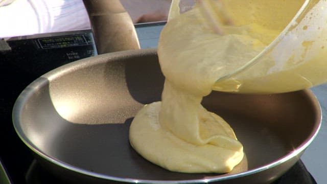 Meringue batter being poured into a frying pan