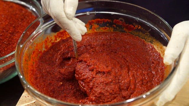 Mixing red pepper paste in a glass bowl