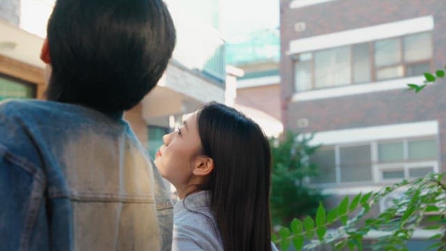 Couple sitting in an alley and looking up