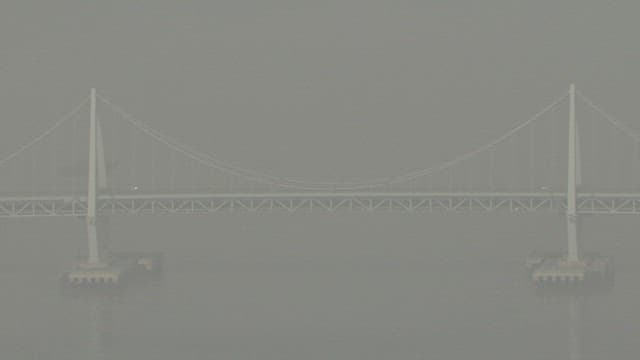 Bridge Over the Calm River in Hazy Air with Fine Dust
