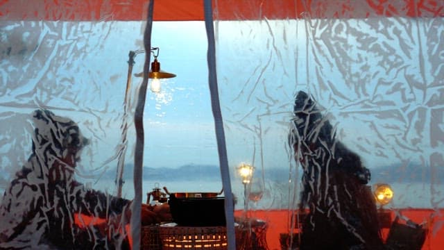 People enjoying drinks and food in a cozy tent