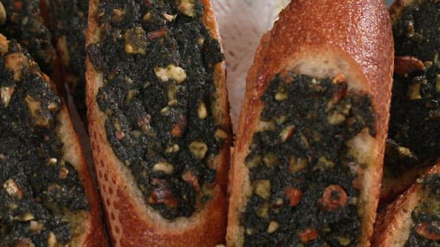Close-up view of freshly baked baguette bread with herb toppings