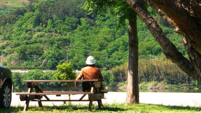 Person wearing a hat and jacket is sitting at a table